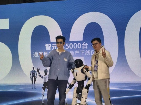 黄晓明与智元第5000台人型机器人同步比心：我很喜欢它的黄色鞋子 因为我姓黄